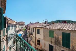 A narrow street with buildings on either side, featuring balconies and a clear sky. - "Borgo 40" Apartment with Balcony and Air Conditioning (Capoliveri)