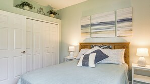 A bedroom with a bed, two bedside lamps, a nightstand, and a door with a mirror. - 8 Mi to Englewood Beach! Canal-Front Family Haven (Rotonda West)