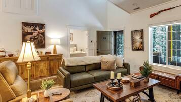 A cozy living room with a green sofa, a wooden coffee table, and a lamp.