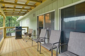 A covered porch with a grill, outdoor seating, and a view of the house's interior. - Private Dock! Lakefront Cherokee Village Retreat (Cherokee Village)