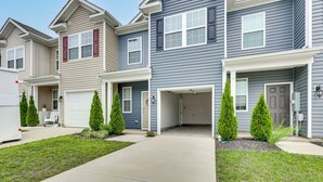 A row of townhouses with attached garages, front porches, and small front yards with trimmed shrubs. - Monthly Stay-Beautiful Townhouse-Luray Attractions (Luray)