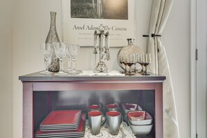 A bar area with a display of glasses and a book titled 'Ansel Adams: The Camera' on the wall. - Monthly Stay-Beautiful Townhouse-Luray Attractions (Luray)
