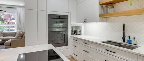 Cafetera o tetera, frigorífico, microondas y placa de cocina