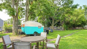A backyard with a turquoise trailer, a round table, and two chairs. - 4 Mi to Cedar Point! Spacious Home w/ Fenced Yard (Sandusky)