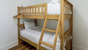 A bunk bed with a ladder, white bedding, and a wooden headboard. - 4 Mi to Cedar Point! Spacious Home w/ Fenced Yard (Sandusky)