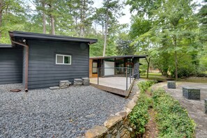 Eine moderne Holzhütte mit Schotterweg und einer Holzterrasse.