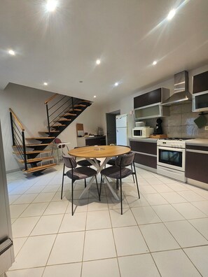 A modern kitchen with a central island, a built-in oven, and a microwave.