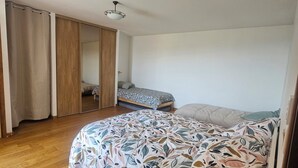 Una camera da letto con un letto, un armadio e una ventola a soffitto.