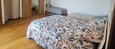 A bedroom with a bed, a wardrobe, and a ceiling fan.