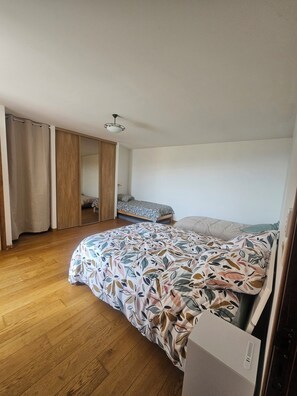 A bedroom with a bed, a wardrobe, and a ceiling fan.