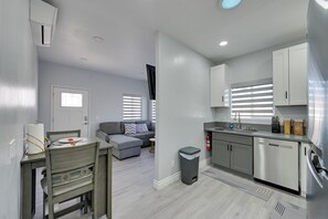 Eine moderne Küche mit Geschirrspüler und einem Essbereich inklusive Tisch und Stühlen.