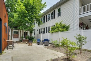 A residential backyard with a patio, outdoor furniture, and a white fence. - Shop, Dine, Walk to Deering Oaks! Family Getaway (Portland)