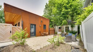 A modern house with a wooden exterior, a patio with outdoor furniture, and a garden area. - Shop, Dine, Walk to Deering Oaks! Family Getaway (Portland)