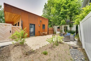 A modern house with a wooden exterior, a patio with outdoor furniture, and a garden area. - Shop, Dine, Walk to Deering Oaks! Family Getaway (Portland)