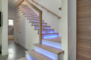 A staircase with wooden steps and a handrail, leading to a landing with a door. - Shop, Dine, Walk to Deering Oaks! Family Getaway (Portland)