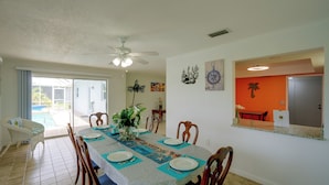 Comedor con una mesa dispuesta para cuatro personas, rodeada de sillas de madera.