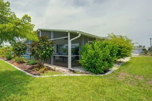 A modern building with a glass enclosure, surrounded by well-maintained grass and various shrubs. - 7 Mi to Beach! Canal-Front Retreat in Rotonda West (Rotonda West)