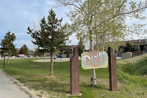 A sign for The Pines Meadowridge, surrounded by trees and a grassy area. - Fraser Condo w/ Pool & Hot Tubs: Close to Trails! (Fraser)