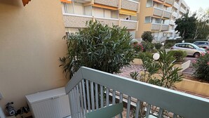 A balcony with a table and chairs, a white radiator, and a potted plant. - Renovated one-bedroom apartment on the Arcachon Bay, right on the beach (Arcachon)