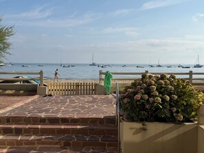 A stone-paved walkway leading to a beach with boats in the water. - Renovated one-bedroom apartment on the Arcachon Bay, right on the beach (Arcachon)