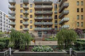 Un immeuble résidentiel à plusieurs étages, doté de balcons, d’une entrée sécurisée et d’un jardin aménagé.
