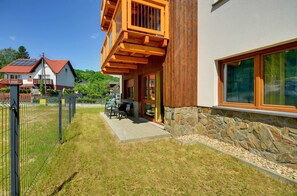 Ein modernes, zweistöckiges Haus mit Steinfundament und Holzbalkon.