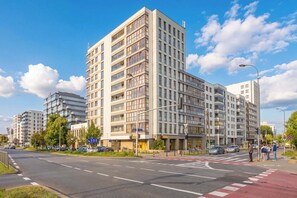 Ein mehrgeschossiges Gebäude mit moderner Architektur, das Balkone und große Fenster kombiniert.