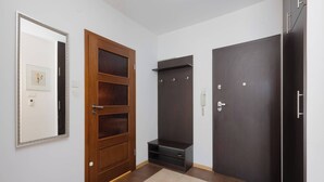 Et værelse med en trædør, en mørk garderobe og et spejl på væggen.