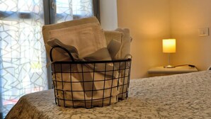 Una camera d'albergo con un letto, una lampada da comodino e una finestra con un motivo geometrico.