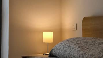 Ein Hotelzimmer mit Bett, Nachttisch und Nachttischlampe.