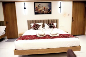 Ein modernes Schlafzimmer mit einem großen Bett, zwei Nachttischen, einer Kopfteil und einem Gemälde an der Wand.
