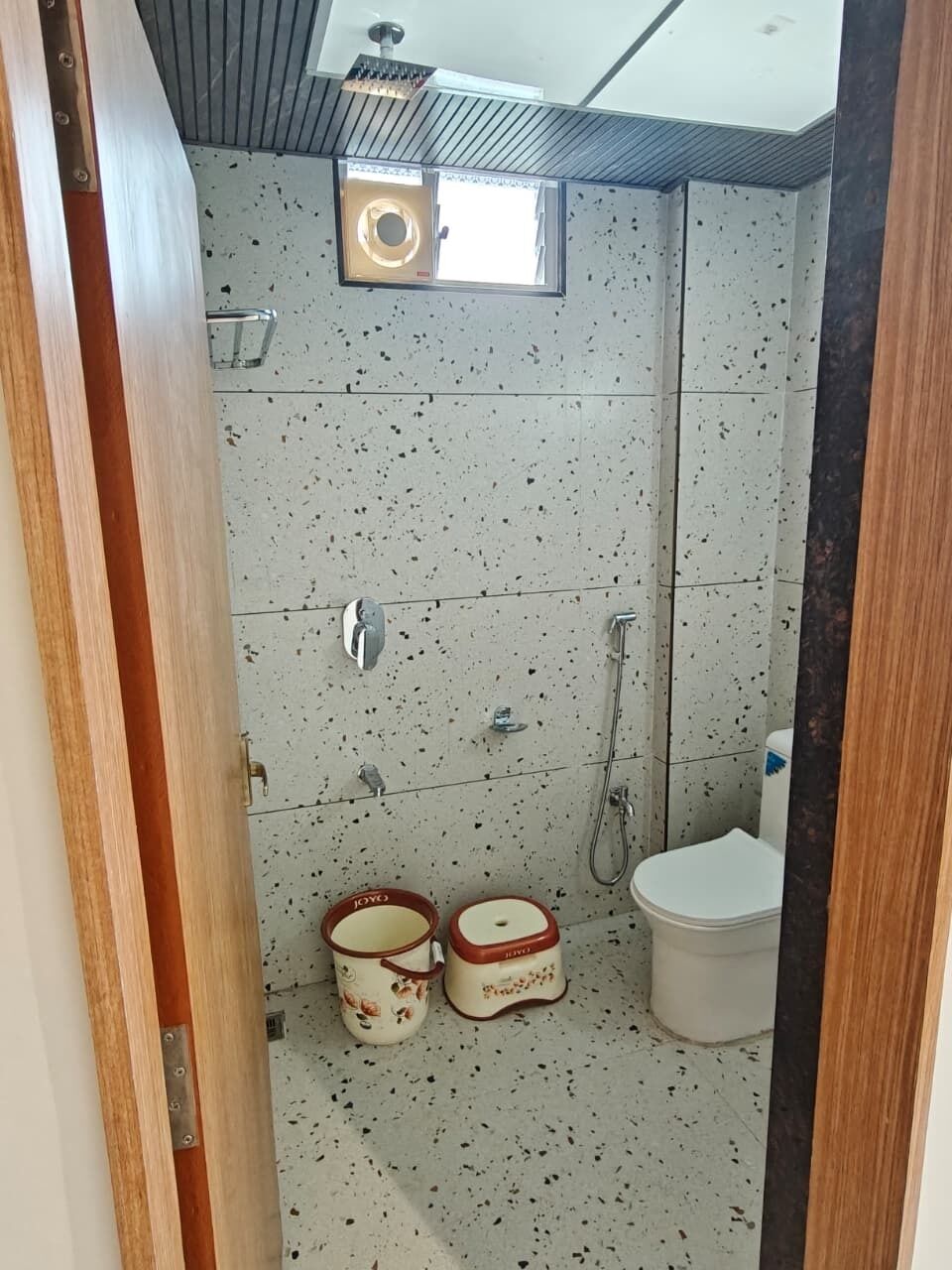 Ett badrum med dusch, toalett och två papperskorgar.