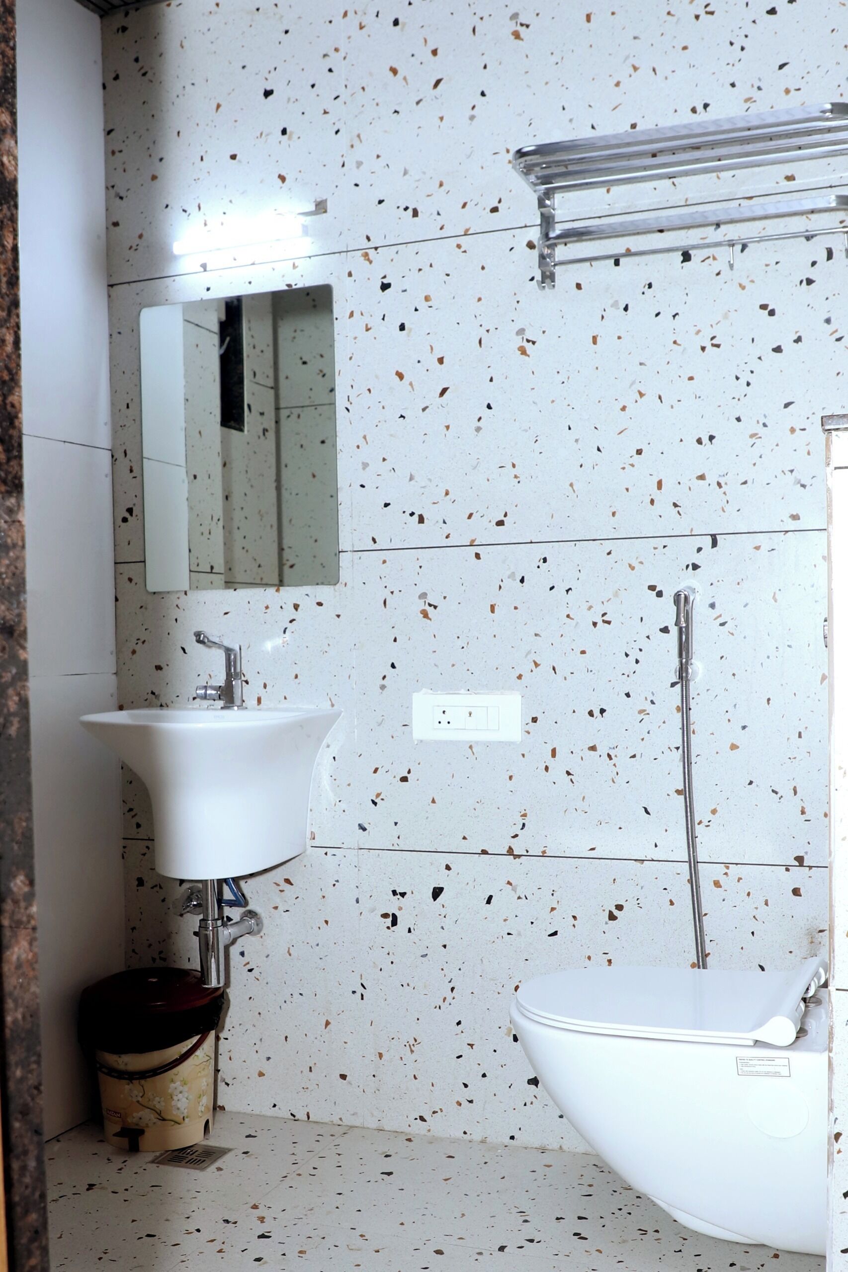 A bathroom with a white sink, a mirror, a toilet, and a shower area.