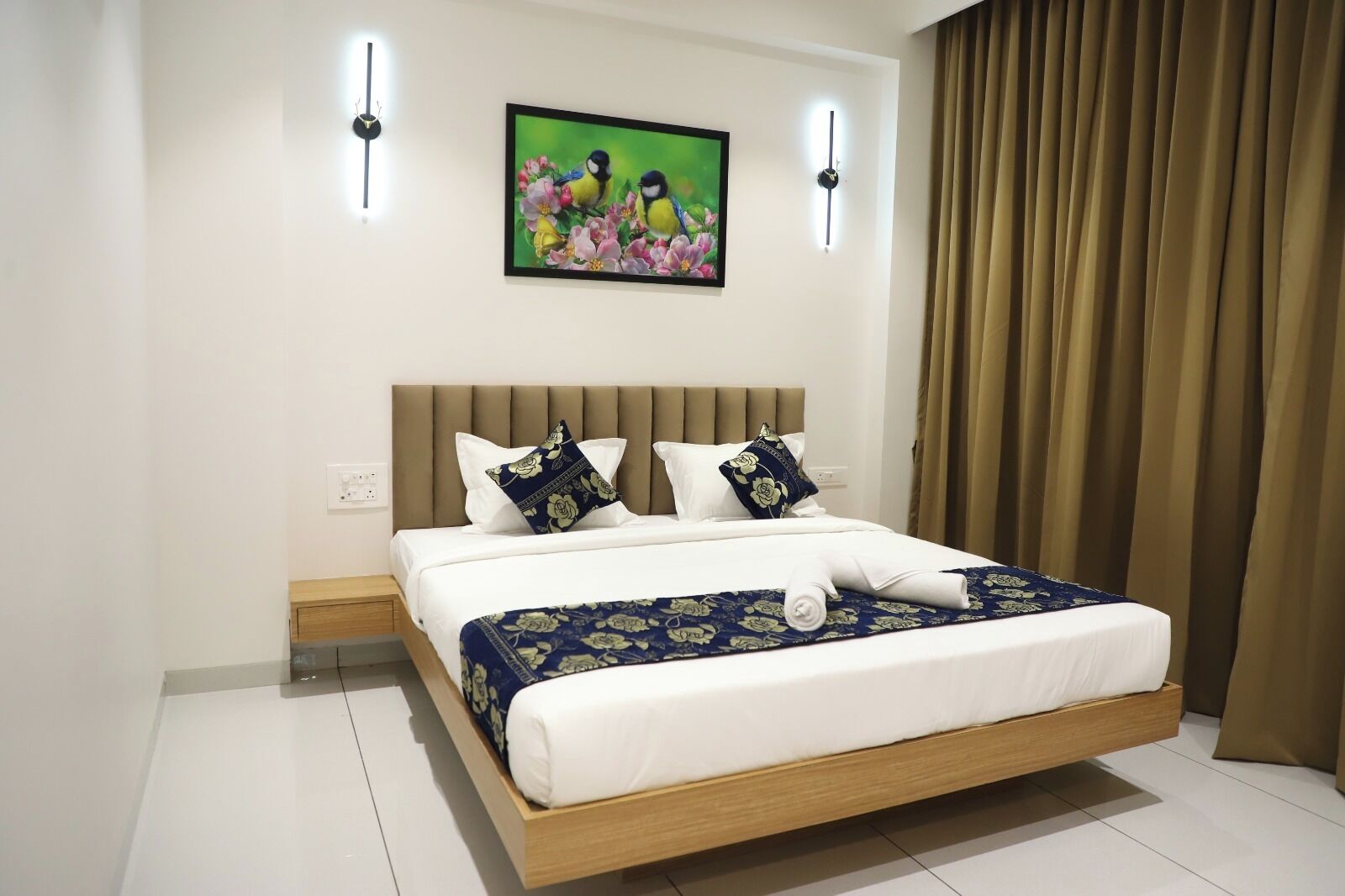 Una habitación de hotel con cama, un cuadro, un reloj y una cortina.
