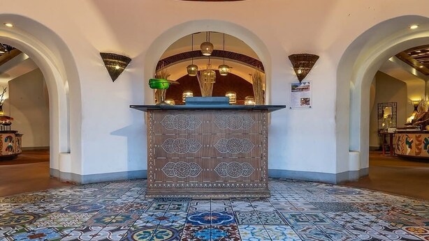 A lobby with a patterned floor, a reception desk, and a decorative ceiling. - Superior Twin room near the victoria falls (Livingstone)