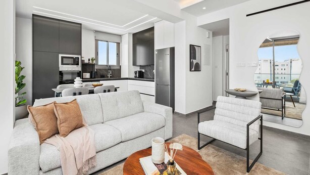 Eine moderne Wohnung mit Wohnbereich, Küche und Essplatz.