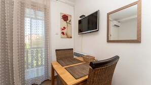 A dining area with a table, chairs, and a TV mounted on the wall. - Beachfront apartment 1 - Dramalj by Villas Guide (Crikvenica)