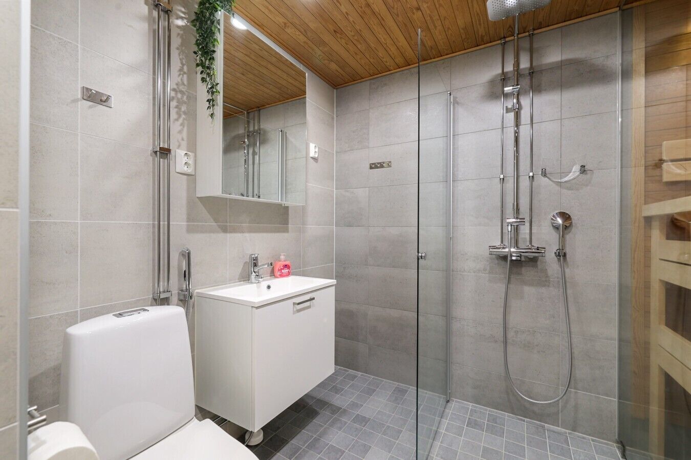 Un baño moderno con ducha de vidrio, lavamanos blanco y bañera.
