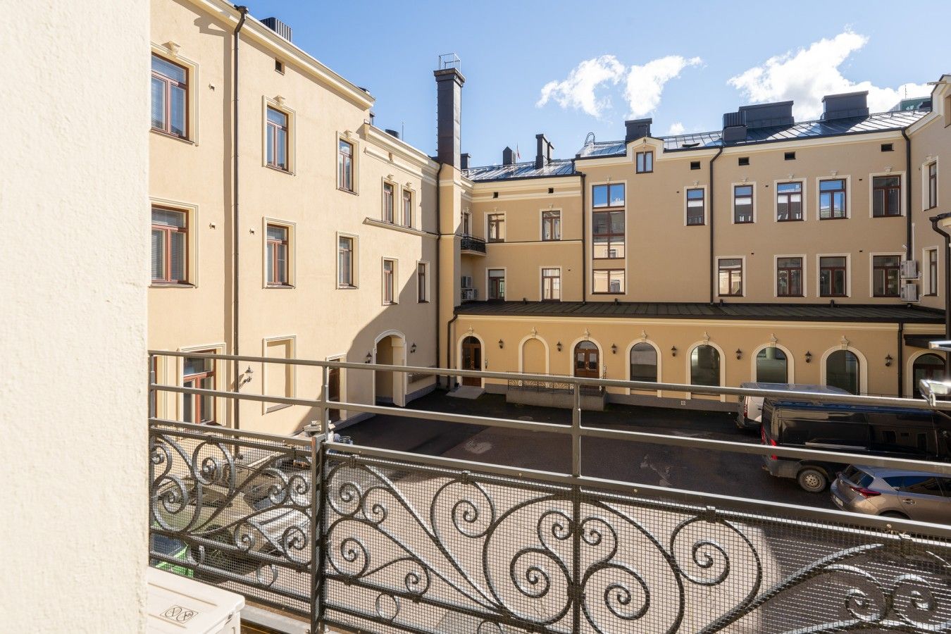 Un immeuble à plusieurs étages doté d’une cour intérieure, de balcons et d’une rambarde en métal.