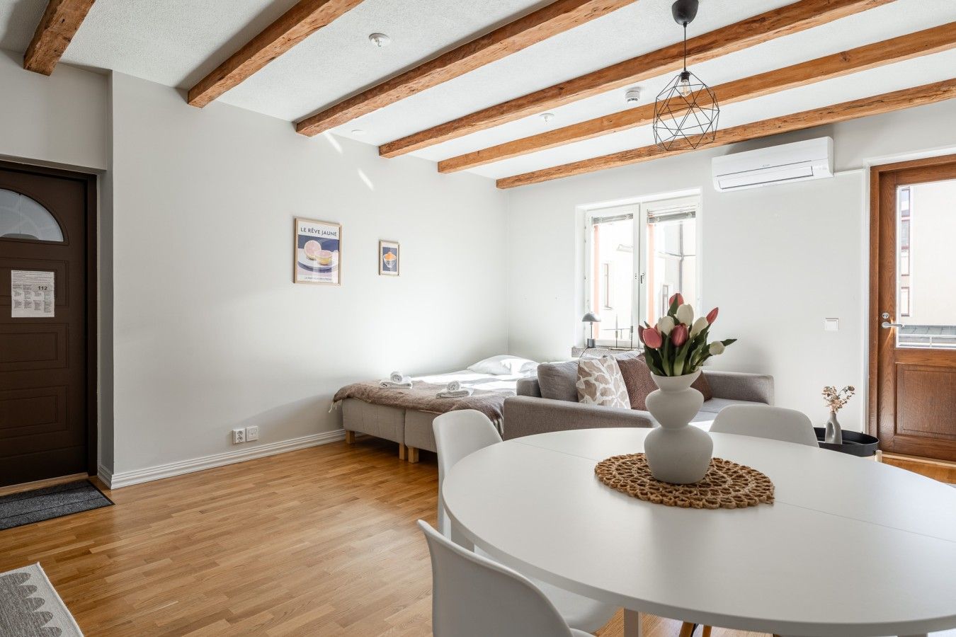 Un salon moderne avec une table blanche, un canapé et un plafond en bois.