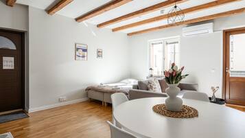 A modern living room with a white table, a sofa, and a wooden ceiling.