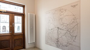 A room with a wooden door, a radiator, and a large map on the wall. - Main Square Studio with Free Parking (Tampere)