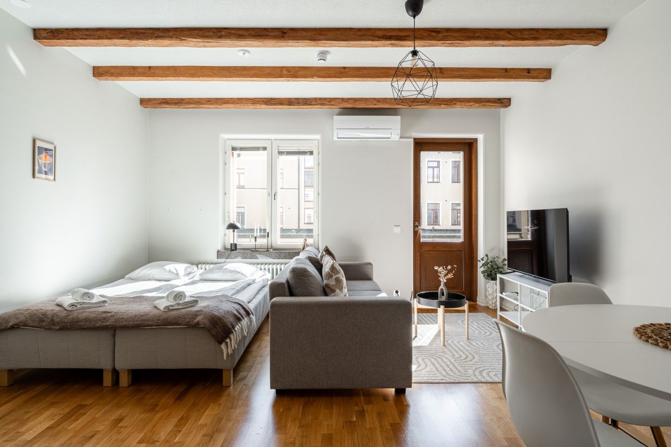 Een moderne woonkamer met een bank, een eettafel en een televisie.