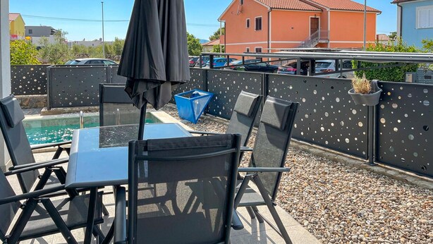 Eine Außenpatio mit Pool, Sitzgelegenheiten und Blick auf eine Wohngegend.