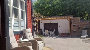 Un'area salotto esterna con mobili in vimini e piante in vaso.