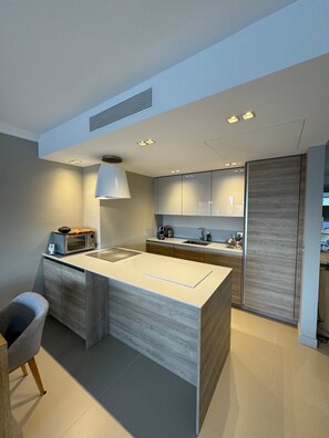 A modern kitchen with a central island, built-in appliances, and a pendant light. - Apartment 'D&L Sea View' with Private Terrace, Wi-Fi and Air Conditioning (Cannes)
