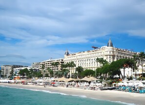 A beachfront hotel with multiple stories, a prominent dome, and a beachside location with umbrellas and lounge chairs. - Apartment 'D&L Sea View' with Private Terrace, Wi-Fi and Air Conditioning (Cannes)