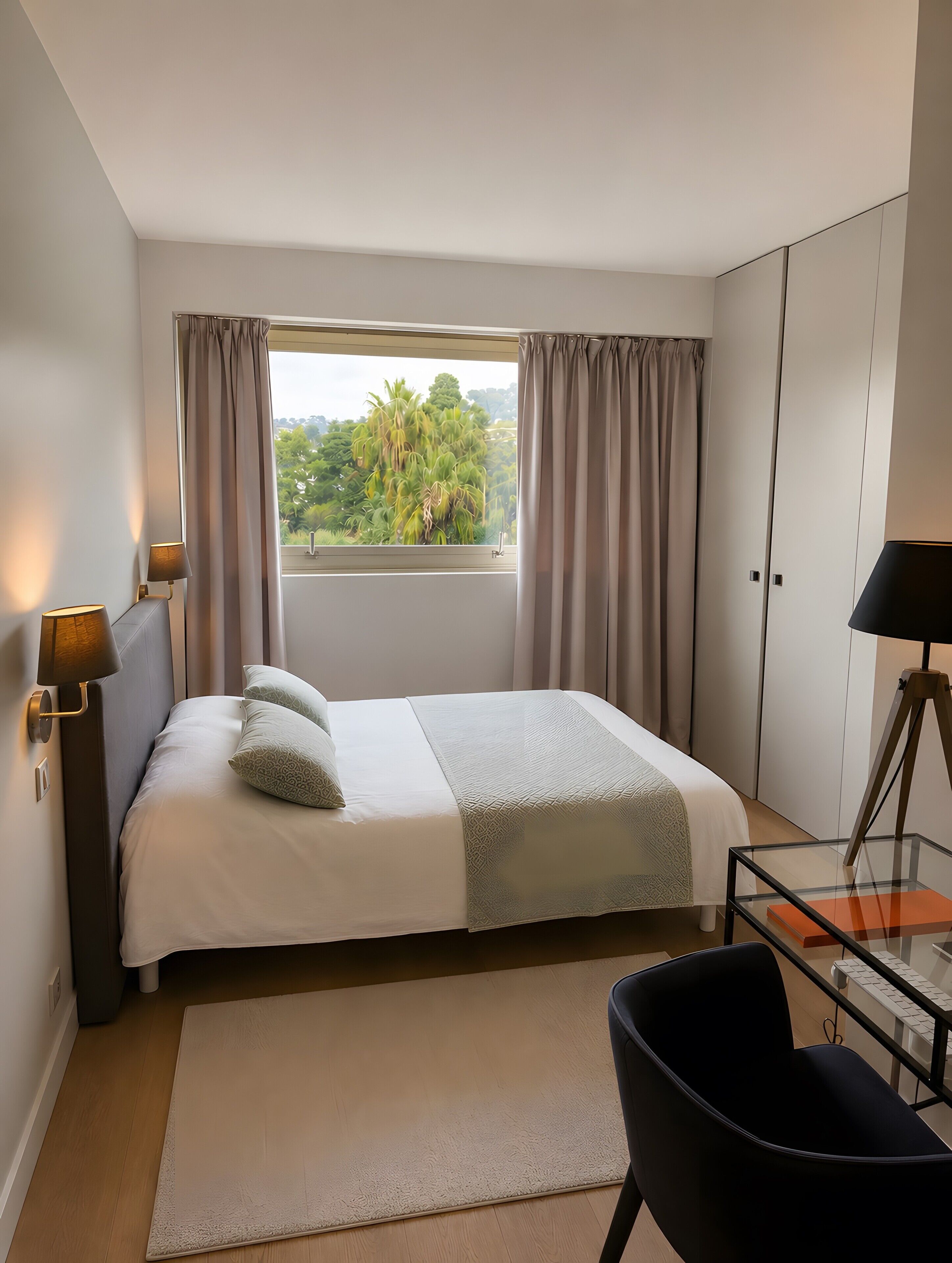 Een hotelkamer met een bed, een bureau, een stoel en een raam met gordijnen.