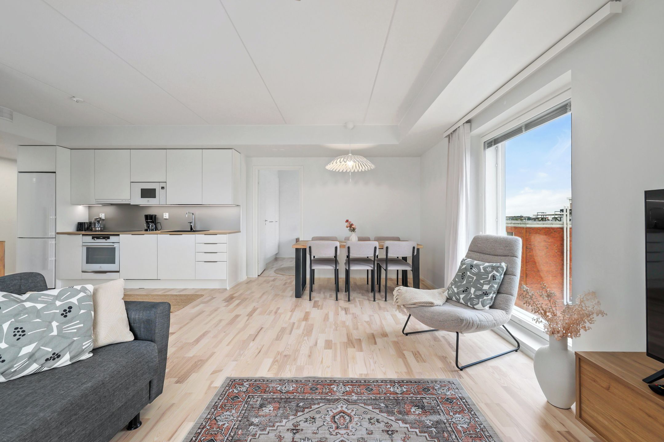 A modern apartment with a kitchen, dining area, and living room.