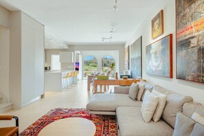 Ein modernes Wohnzimmer mit Sofa, Essbereich und Küche.